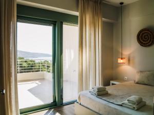 a bedroom with a bed and a large window at K Villas in Plataria +195 photos