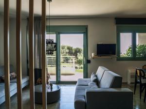 a living room with a blue couch and a living room with a window at K Villas in Plataria