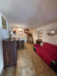 a living room with a red couch and a table at Vecchio Mulino- Via Paier in Entracque
