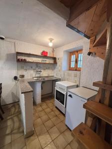 a kitchen with a white stove and a sink at Vecchio Mulino- Via Paier in Entracque
