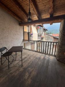 a table and a chair on a porch with a balcony at Vecchio Mulino- Via Paier in Entracque