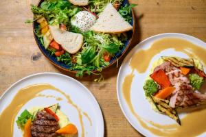 a table with two plates of food and a salad at Koning te Rijk - Residence de Eese in De Bult