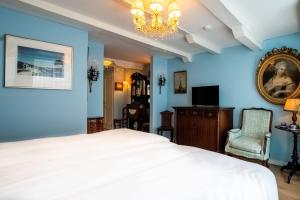 a bedroom with blue walls and a bed and a chandelier at Hotel Bet van Beeren in Amsterdam
