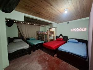 a room with two beds and two chairs at Hostal Puerto del Reino in Puerto Colombia