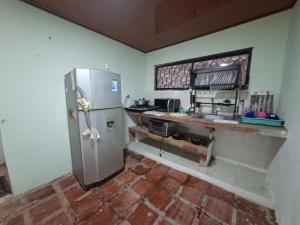 a kitchen with a stainless steel refrigerator and a counter at Hostal Puerto del Reino in Puerto Colombia +14 photos