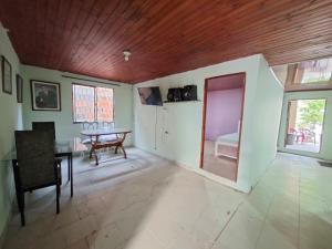 a living room with a table and a wooden ceiling at Hostal Puerto del Reino in Puerto Colombia