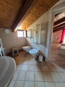 a bathroom with two toilets and a tub and a sink at Dimora Suriano in Altamura