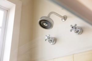 a shower with two faucets on a wall at Hotel Boutique Inconfidentes in Tiradentes +43 photos