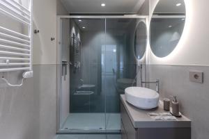 a bathroom with a glass shower and a sink at Dune Luxury Residence in Turin +13 photos