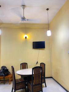 a dining room with a table and chairs and a tv at Jaans Inn in Ratmalana South