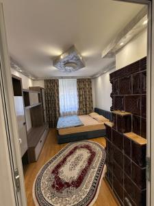 a small bedroom with a bed and a large rug at Kaira place in Lupeni