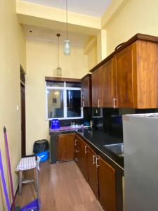 a kitchen with wooden cabinets and a white refrigerator at Jaans Inn in Ratmalana South