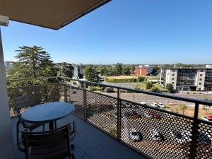a balcony with a table and a view of a city at DOMITYS - Purpan Pèira Ròsa in Toulouse