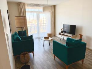 a living room with two chairs and a television at DOMITYS - Purpan Pèira Ròsa in Toulouse