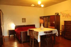 a bedroom with a bed and a table with a vase on it at Lilac Orbeti - Cool Climate Country House Near Tbilisi in Pantiani