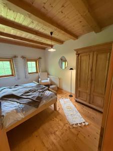 a bedroom with a bed and a chair in it at Ferienwohnung Eggerhof-Schaller in Innervillgraten +18 photos
