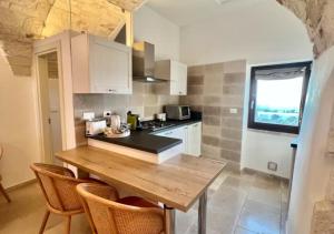 a kitchen with a wooden table and some chairs at Casa Leo with Jacuzzi in Ostuni