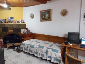 a bedroom with a bed and a desk with a television at ΑΝΝΑ'S Πύργος - ΣΑΜΟΣ in Pýrgos