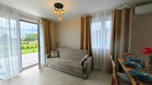 a living room with a chair and a table and a window at Luna Lake - Twój azyl nad Jeziorem Białym in Gostynin +6 photos