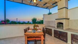 a table and chairs on a patio with a fireplace at Secluded Sea View Honeymoon Escape Jacuzzi Private Pool-Villa Bella1 Orkide in Üzümlü