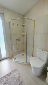 a bathroom with a glass shower and a toilet at Luna Lake - Twój azyl nad Jeziorem Białym in Gostynin