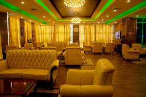 a waiting room with couches and chairs and green lights at Galaxy La Palm Royal Hotel in Port Harcourt