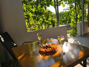 a bowl of fruit and two glasses of wine on a table at Garden Room with Private Patio Salamis in Eantio