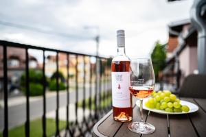 a bottle of wine and a plate of grapes on a table at Gere Art&Exclusive Apartments in Harkány +32 photos