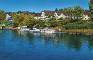 a group of boats docked in a river with houses at Rhein River Guesthouse - direkt am Rhein in Leverkusen