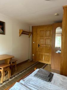 a bedroom with a bed and a table and a wooden door at Plai in Dragobrat +123 photos