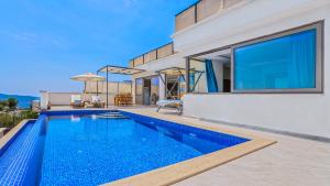 a swimming pool in the backyard of a house at Secluded Sea-View Romantic Escape Villa Bella 4 Leylak in Üzümlü