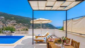 a patio with a table with an umbrella and a pool at Secluded Sea-View Romantic Escape Villa Bella 4 Leylak in Üzümlü