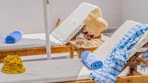 a room with two beds and a table with glasses of wine at Secluded Sea-View Romantic Escape Villa Bella 4 Leylak in Üzümlü
