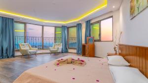 a bedroom with a bed and some chairs and windows at Luxury Valley-View Escape in Islamlar -Villa 5 Kartal Yuvası in Üzümlü +79 photos