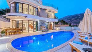 a villa with a swimming pool in front of a house at Luxury Valley-View Escape in Islamlar -Villa 5 Kartal Yuvası in Üzümlü
