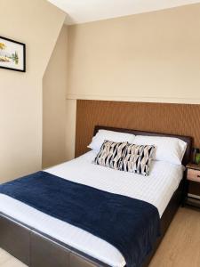 a bedroom with a large bed with a blue blanket at Wellingborough Luxury Staycation 3 Bed 2 Bath in Wellingborough