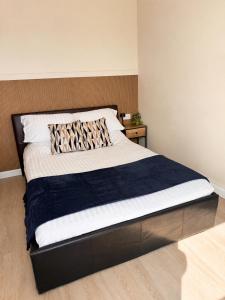 a bedroom with a large bed with a wooden headboard at Wellingborough Luxury Staycation 3 Bed 2 Bath in Wellingborough +28 photos