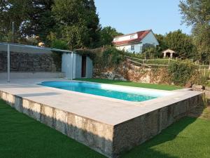a swimming pool in a yard with a stone retaining wall at La minada in Covelo +17 photos
