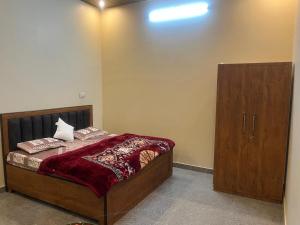 a bedroom with a bed and a wooden cabinet at lavender hill in Jaipur