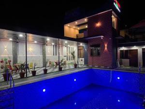 a swimming pool in front of a house at night at lavender hill in Jaipur