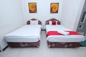 two beds sitting next to each other in a room at Omah Ambarukmo in Yogyakarta +17 photos
