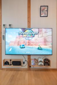 a large flat screen tv on a wall with a video game at Cove琴平 - 1組貸切 最大8名 こんぴらさん徒歩すぐ in Kotohira