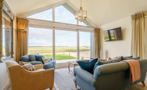 ein Wohnzimmer mit zwei Sofas und einem großen Fenster in der Unterkunft 1 Pheasant in East Ilsley