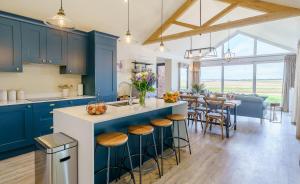 eine Küche mit blauen Schränken und ein Esszimmer in der Unterkunft 1 Pheasant in East Ilsley