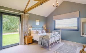 ein Schlafzimmer mit einem Bett und einem großen Fenster in der Unterkunft 1 Pheasant in East Ilsley
