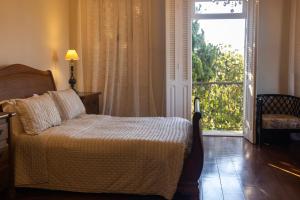 a bedroom with a bed in front of a window at Hotel Boutique Inconfidentes in Tiradentes