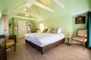 a bedroom with a large bed and a chair at Hotel Bet van Beeren in Amsterdam