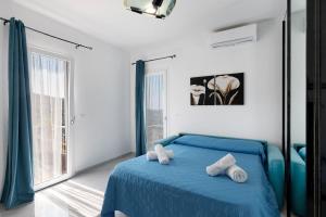 a bedroom with a blue bed and a large window at Casa Rosetta - vicino Bordighera in Vallebona