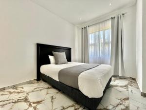 a bedroom with a large bed and a window at Number 15 Jadde Apartments in Sandton