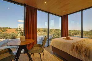 a bedroom with a bed and a table and some windows at Cork Valley - Mirror Houses in Hontanar +78 photos